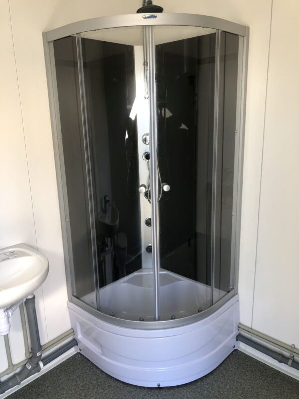 js9 Contentor sanitário com chuveiro, lavatório e sanita.